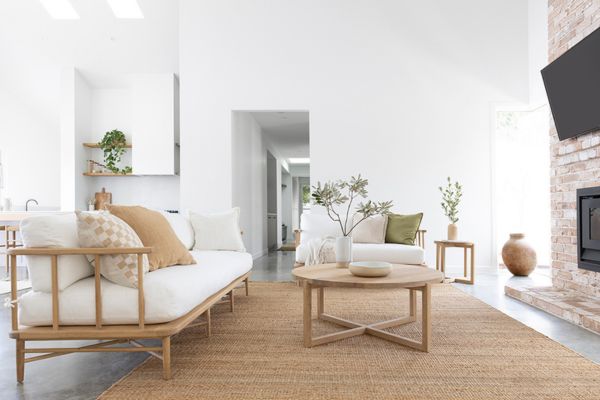 Modern coastal living room with sofa, occasional chairs and coffee table arranged with balanced spacing for comfortable flow and conversation.