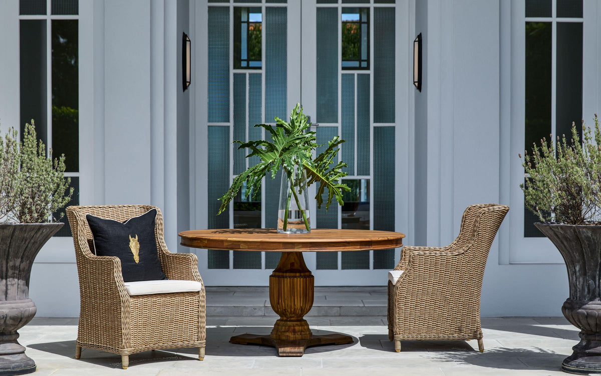 Ashford natural woven outdoor dining chairs with light seat cushions in an outdoor dining setting
