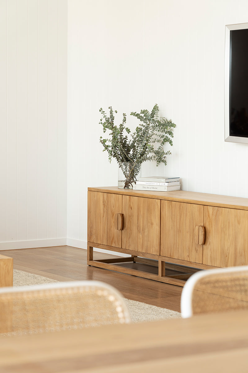 Angled lifestyle view of the Benji 3m natural teak entertainment unit in a bright living and dining room