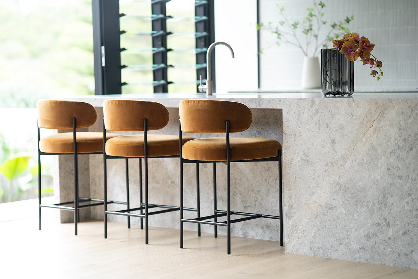 Fontaine Counter Stool with half-moon curved back and metal legs, upholstered in performance velvet in amber, modern Art Deco inspired counter stool for elegant interiors. Elegant modern kitchen.