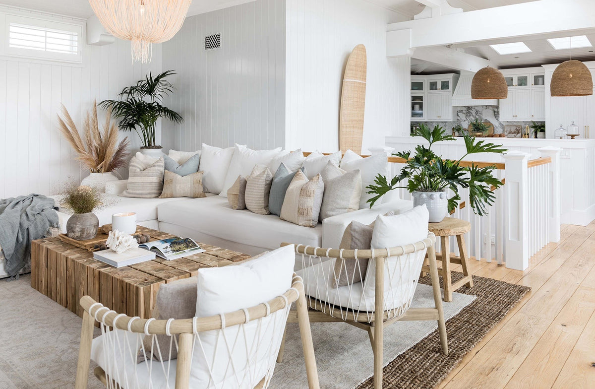 Hamali square teak coffee table beside a white sectional sofa in a light-filled living room