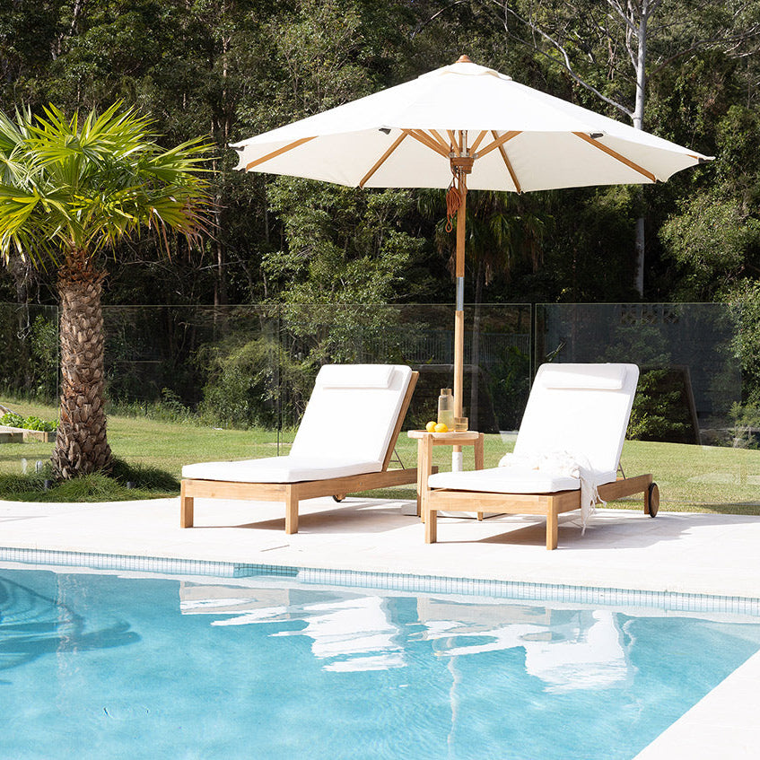 Harbour Island Slim Outdoor Sunlounger in Grade A teak with white Sunbrella cushion, adjustable backrest and wheels, coastal outdoor furniture for poolside or garden relaxation. Coastal style living.