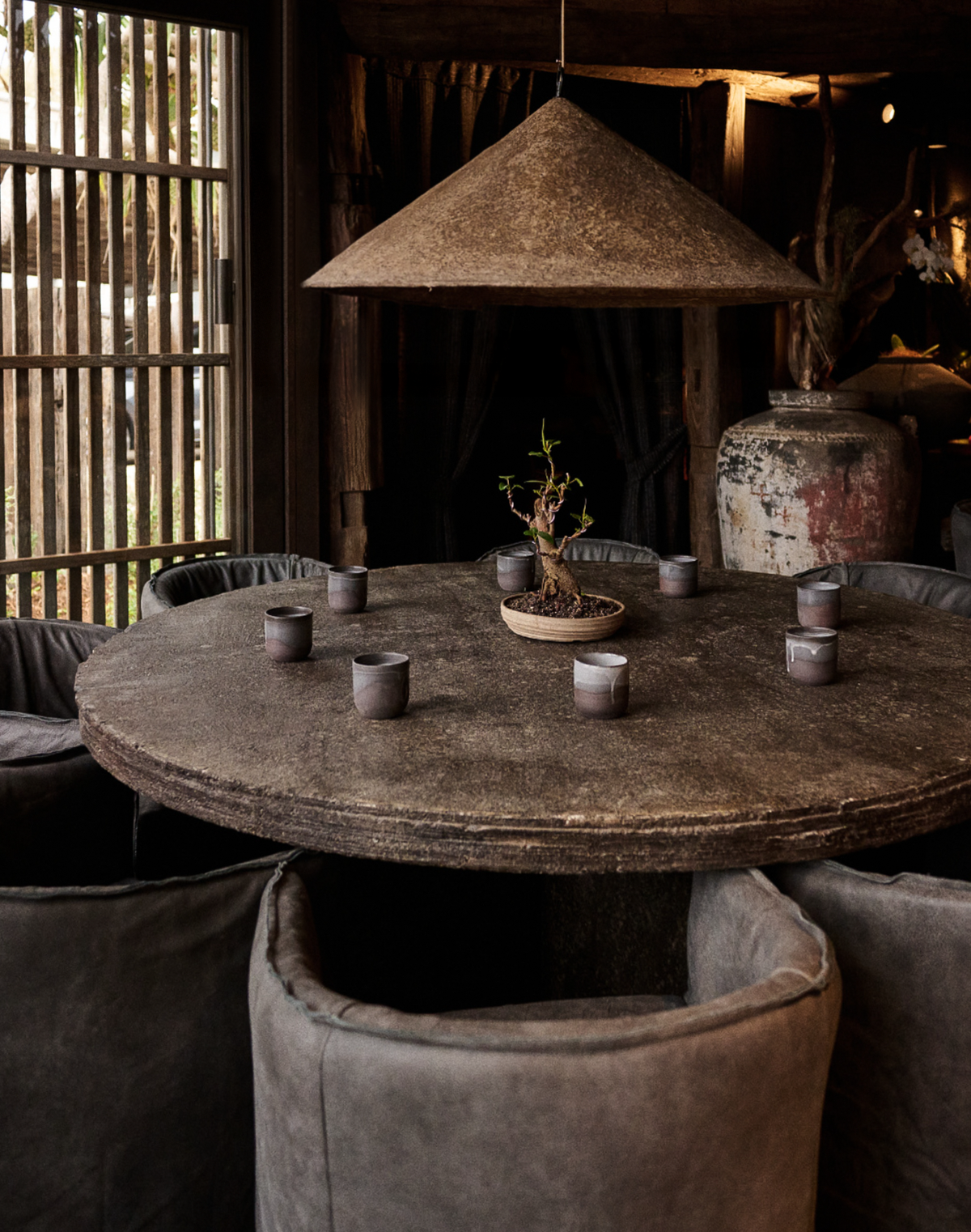 Khufu Pendant Large in Dark Roast suspended above a dining table, in a organic modern dining interior.