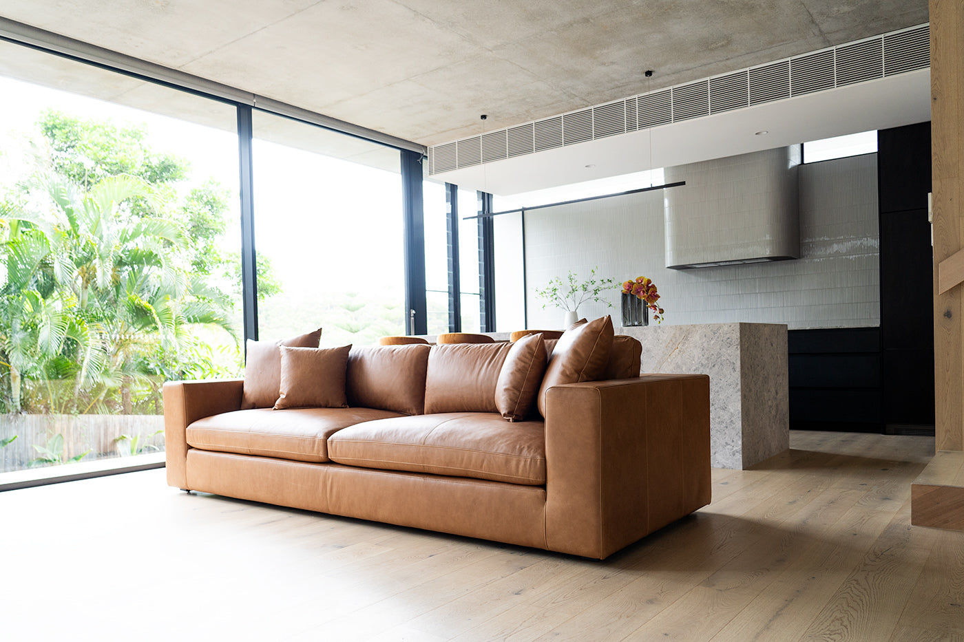 Lucca Four Seater Sofa in trend saddle tan leather with sleek, sophisticated design. Styled in this modern interior.