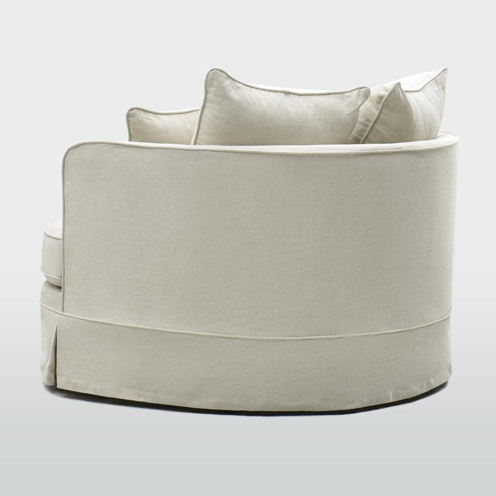 Rear view of the Noosa beige snuggle chair showing the curved upholstered back and tailored skirt