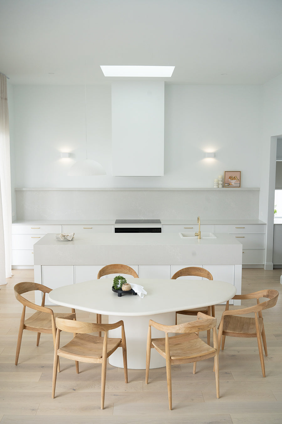 Saint Tropez Dining Table with ivory micro cement finish – modern coastal design with organic shape and refined matte texture. Styled beautifully in this luxury coastal home 2