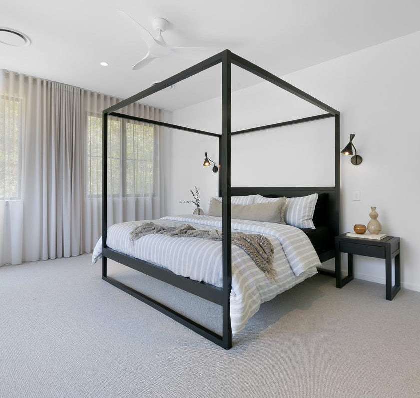 Black Strand four-poster bed styled in a contemporary bedroom with matching bedside tables