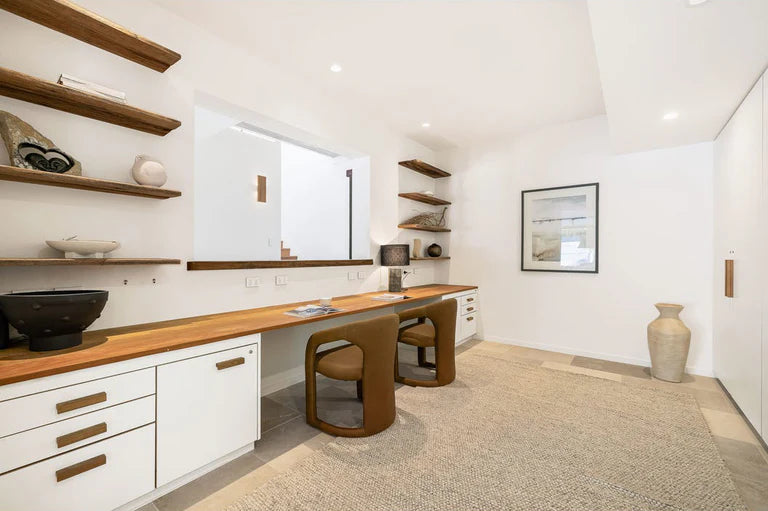 Fikile Dining Chair – contemporary chair with swooping open back, upholstered leather seat, and rounded silhouette, blending vintage style with modern elegance for dining or accent use as shown in this study