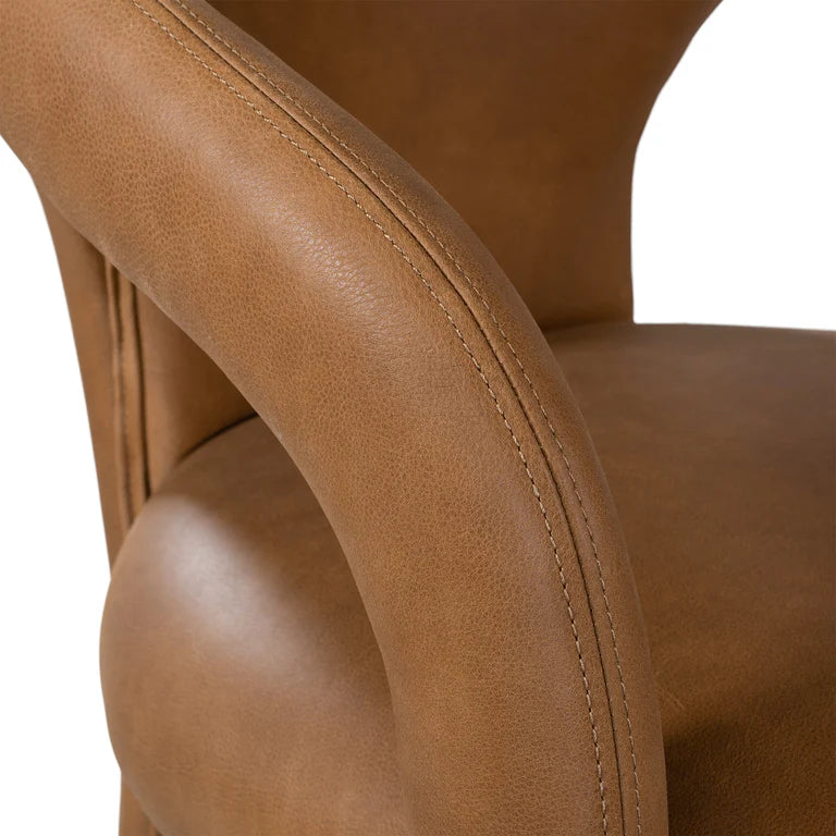 Fikile Dining Chair – contemporary chair with swooping open back, upholstered leather seat, and rounded silhouette, blending vintage style with modern elegance for dining or accent use. Close up.