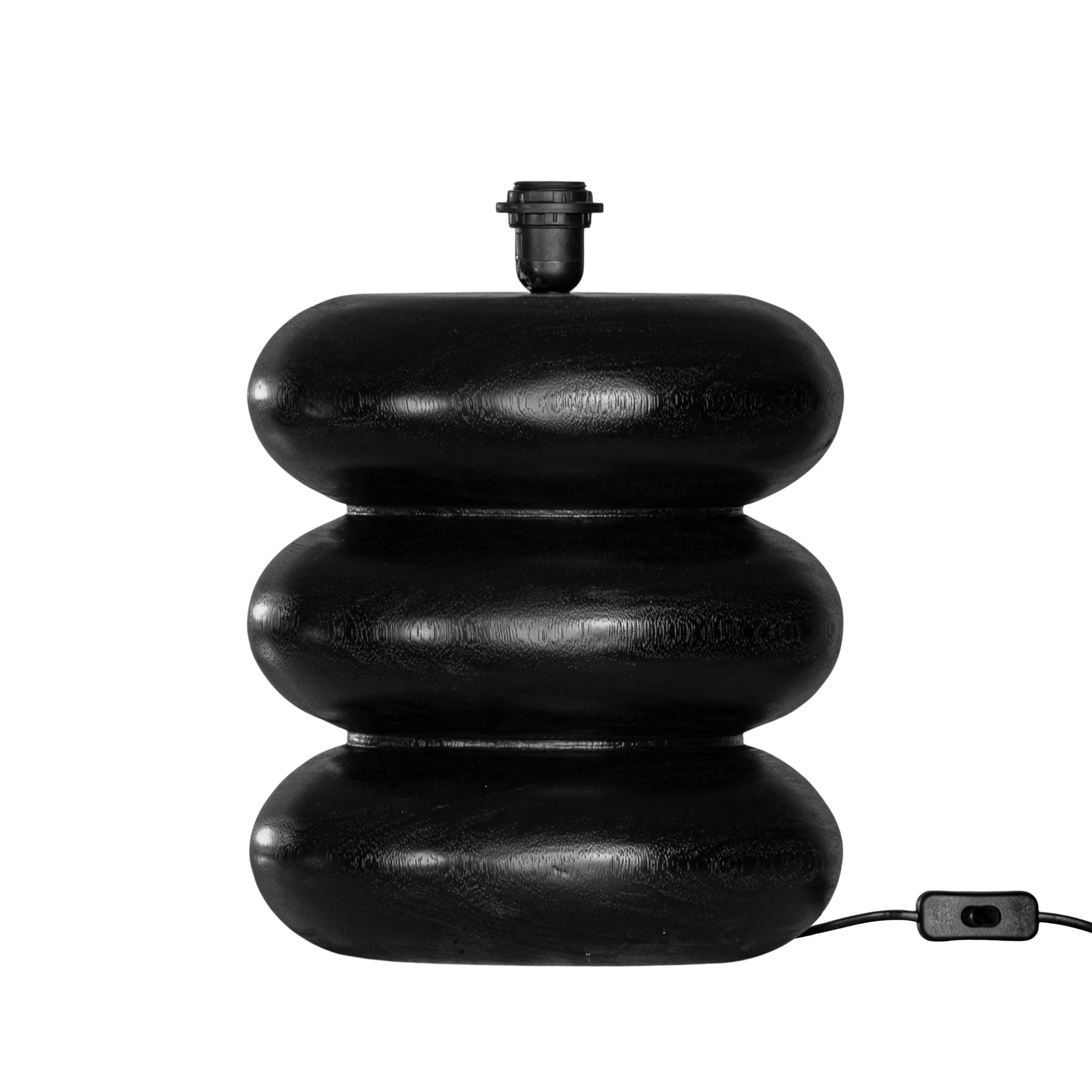 Rundu Table Lamp handcrafted from solid munggur wood with hand-carved textured grooves, showcasing natural wood variations and a soft ambient glow. Close up black base.