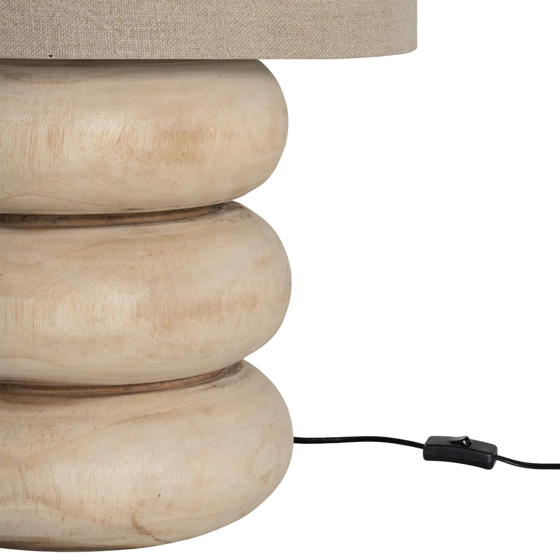Rundu Table Lamp handcrafted from solid munggur wood with hand-carved textured grooves, showcasing natural wood variations and a soft ambient glow. Close up with cable.