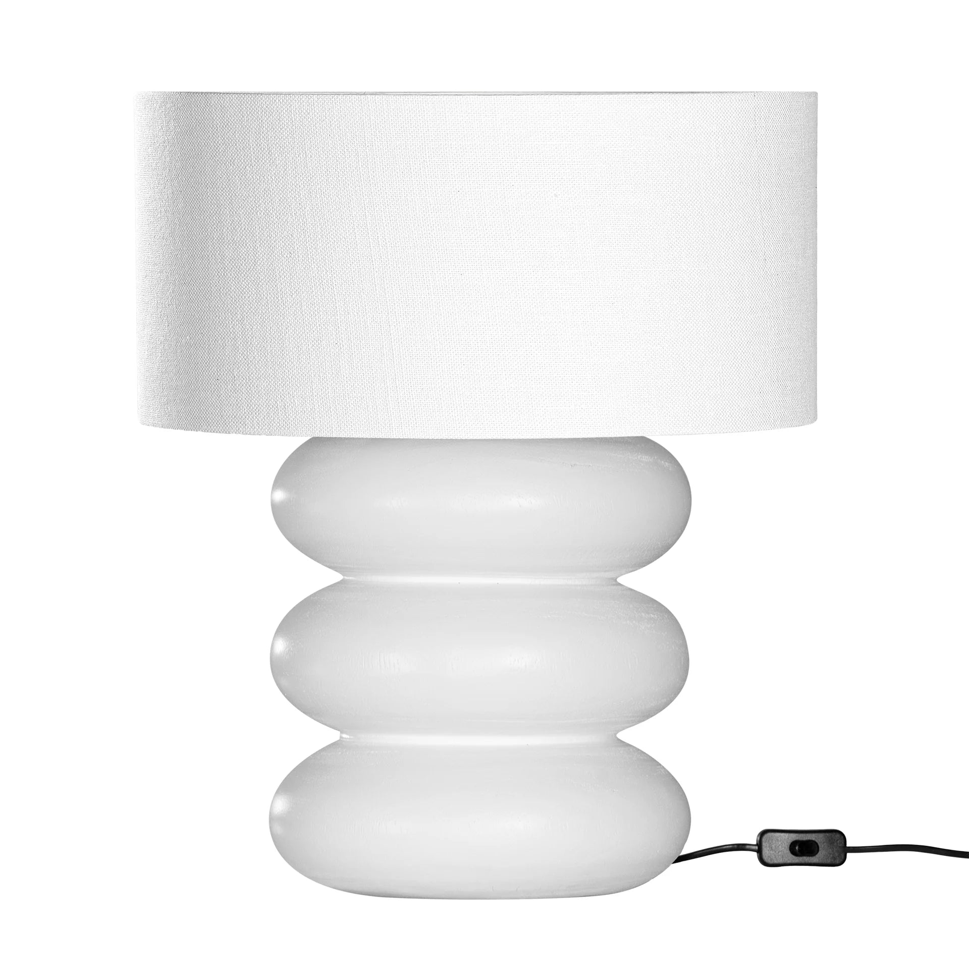 Rundu Table Lamp handcrafted from solid munggur wood with hand-carved textured grooves, showcasing natural wood variations and a soft ambient glow. White base with white shade.