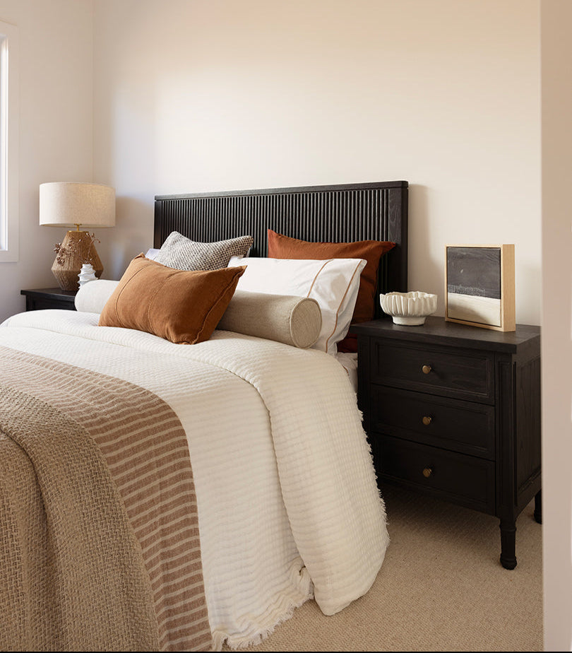 Whitsunday 3 Drawer Bedside Table in black with fluted legs and natural cane shelf, solid hardwood coastal bedroom furniture. Modern interior.