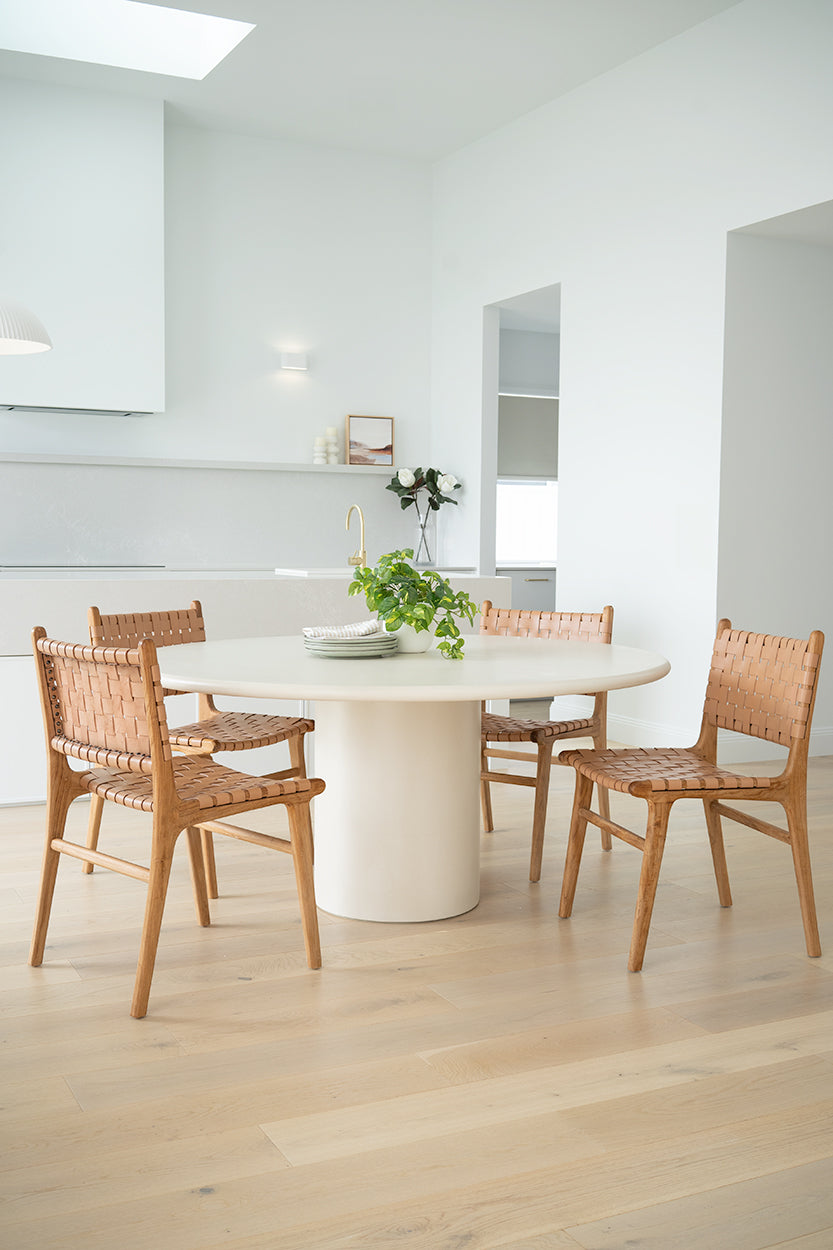 Dining chair with natural woven leather straps and sleek modern design, crafted for style and comfort. Styled perfectly in this modern coastal home. Magnolia Lane 1