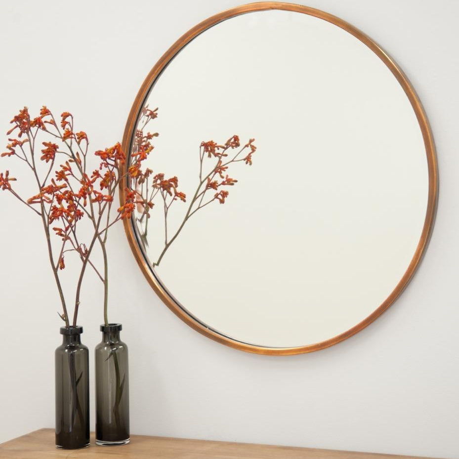 Arthur Copper Mirror – round wall mirror with minimalist copper-look metal frame, handcrafted for a unique, contemporary design. Available via Magnolia Lane