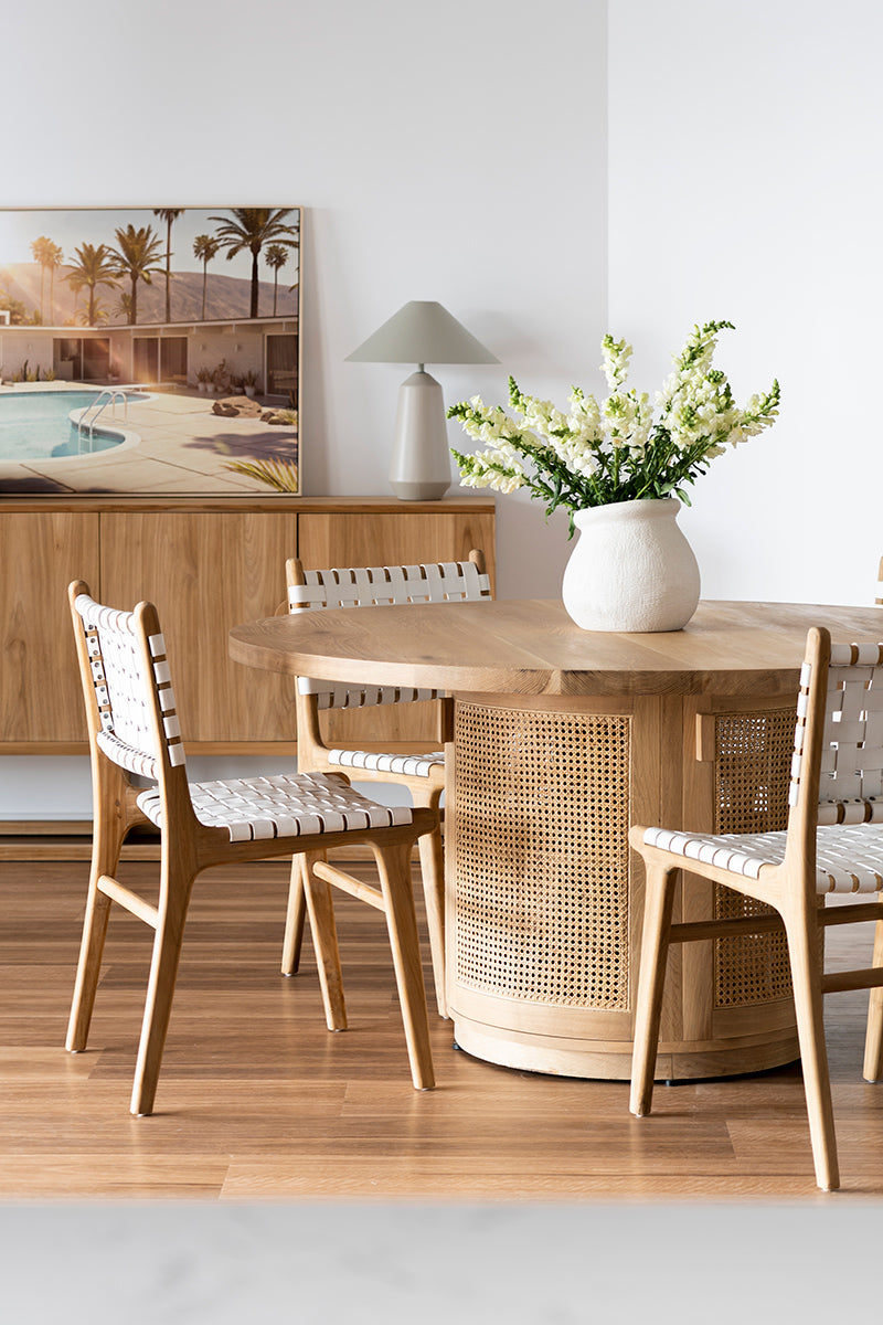 Dining chair with white woven leather straps and sleek modern design, crafted for style and comfort. Styled beautifully in this modern coastal interior. Magnolia Lane