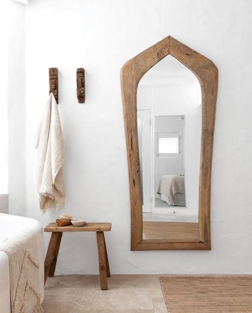 Karoo Mirror by Uniqwa Collections, handcrafted from rare antique Indonesian teak ploughs, showcasing unique shapes and rich cultural heritage. Styled in modern home.