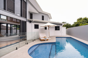 Amalfi Outdoor Parasol with teak pole and marine-grade fittings, round Sunproof Copacobana shade, elegant coastal outdoor umbrella for poolside or garden.  Coastal poolside living.