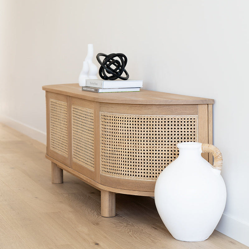 Solid oak entertainment unit with curved edges styled in coastal living room