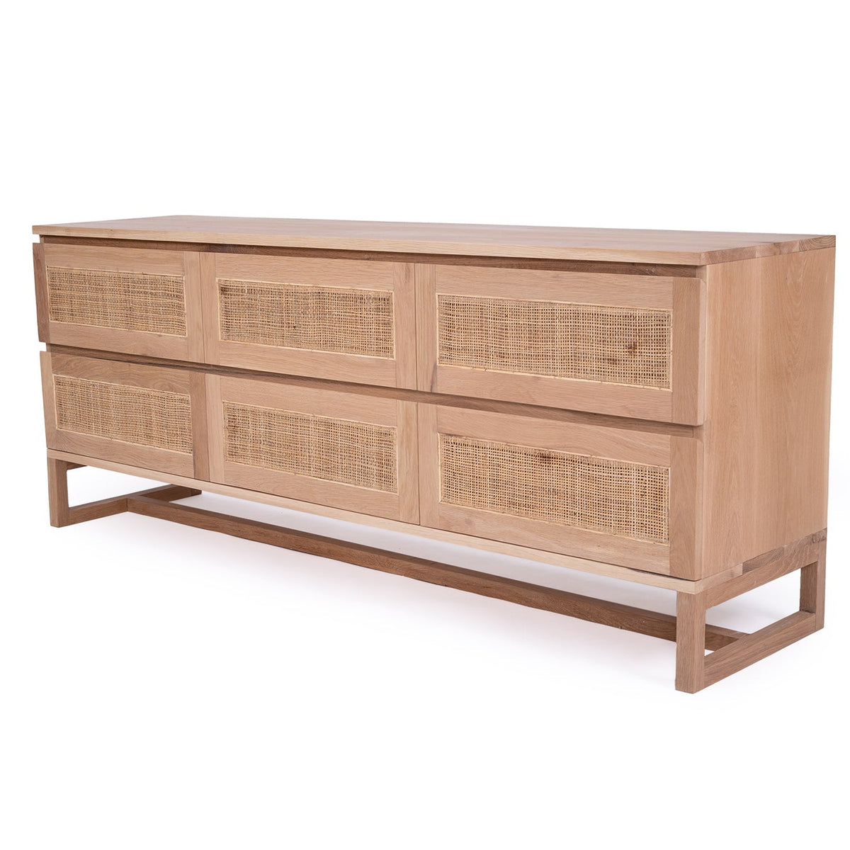 Angled view of the Beach House oak chest showing rattan drawer fronts and timber frame