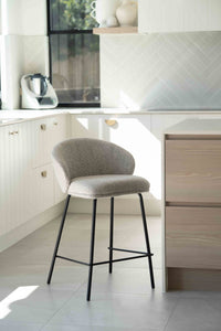 Bellevue Counter Stool with padded Pebble fabric seat and back, slim black powder-coated steel frame, modern elegant design. Styled beautifully in this modern kitchen.