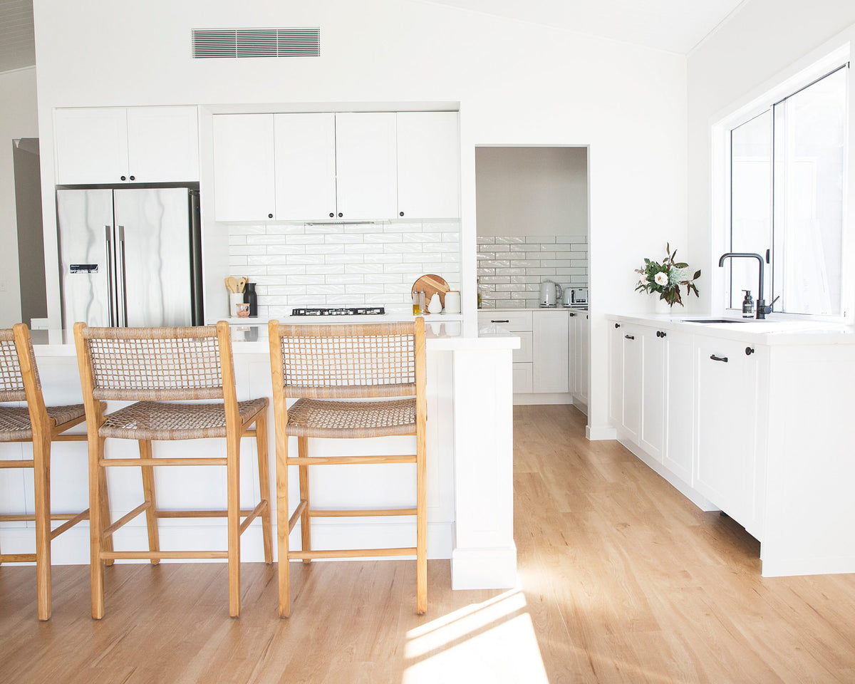 Bondi washed grey counter stools styled at a white kitchen island in a bright coastal interior