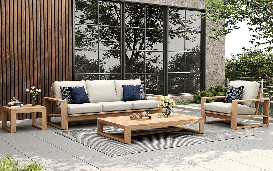 Oversize teak coffee table styled with outdoor sofas and chairs in a garden setting
