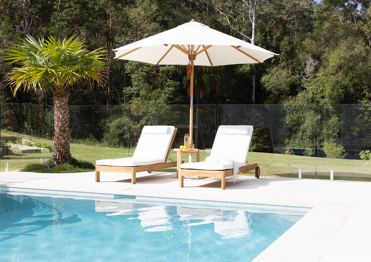 Harbour Island Slim Outdoor Sunlounger in Grade A teak with white Sunbrella cushion, adjustable backrest and wheels, coastal outdoor furniture for poolside or garden relaxation.  Coastal style living.