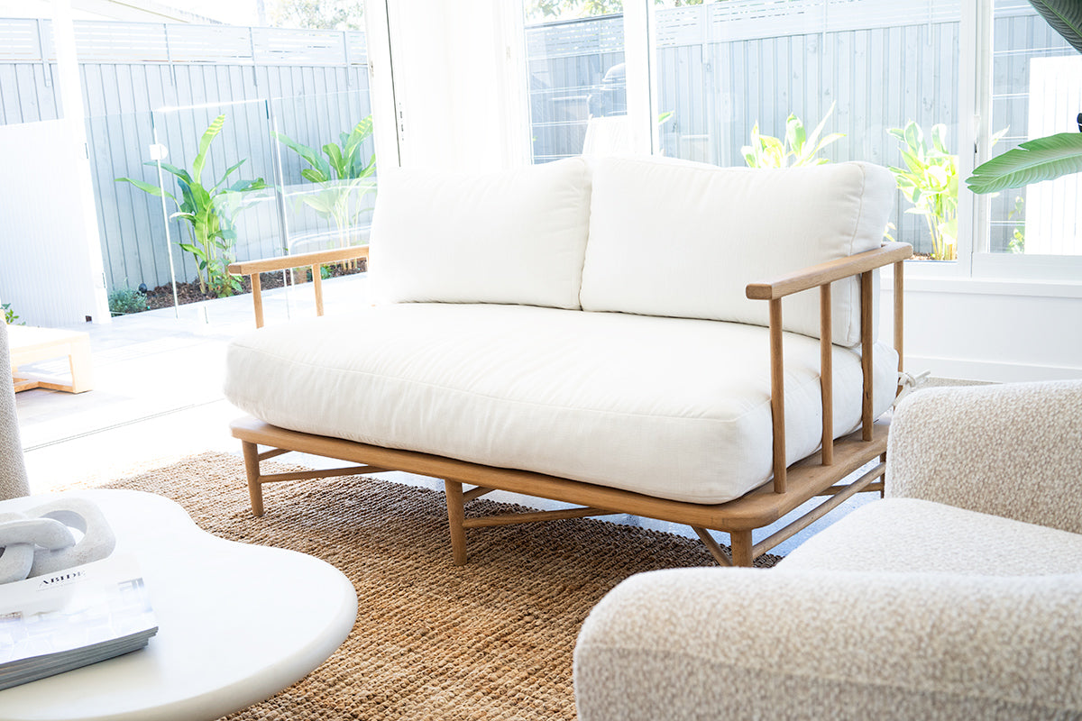 The Harbour Island Two Seater Sofa with light timber frame and white cushions – coastal luxe design perfect for relaxed modern interiors