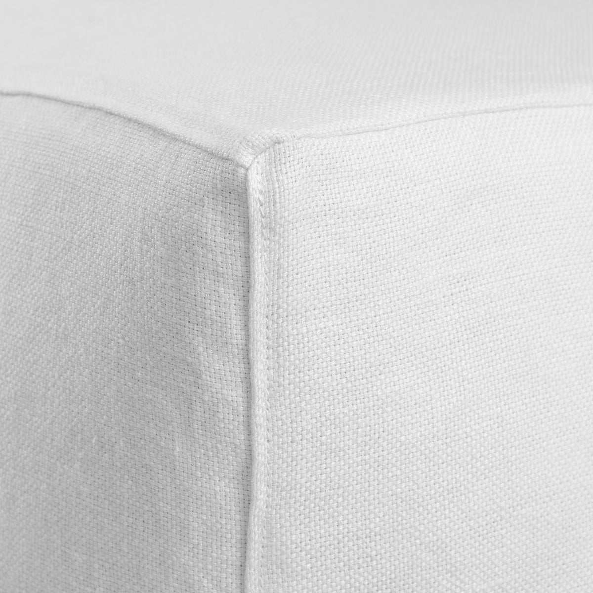 Close-up of the Hendrix Modular Ottoman by Uniqwa Collections featuring the Casual Stitch topstitched seam detail on a premium removable linen slipcover.