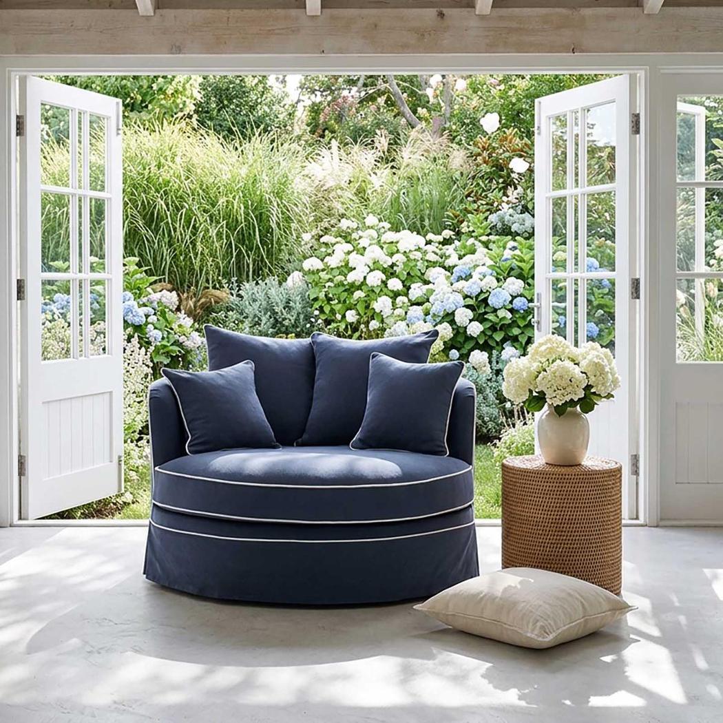 Noosa snuggle occasional chair in Navy with White Piping, styled indoors beside open garden doors
