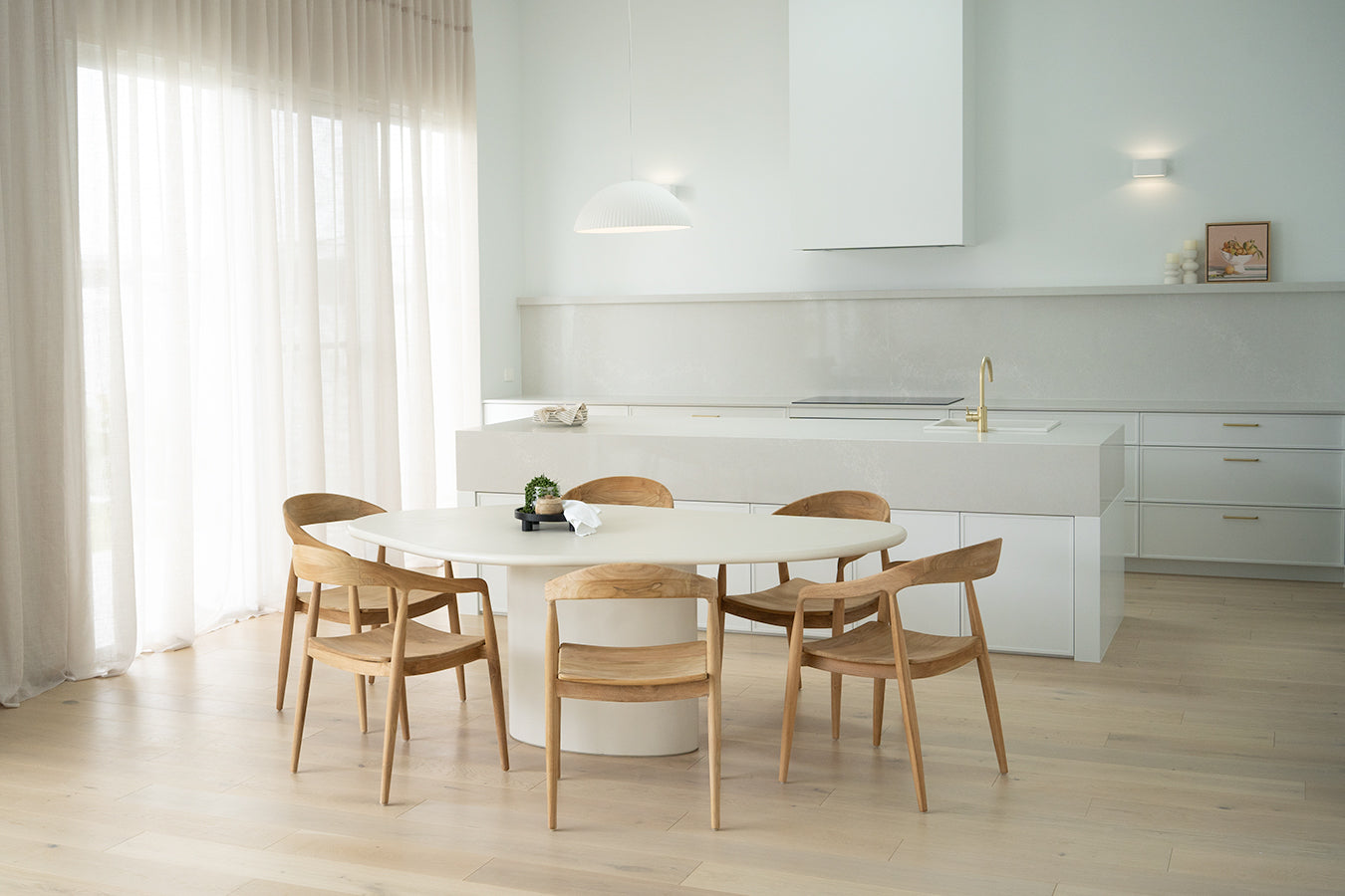 Saint Tropez Dining Table with ivory micro cement finish – modern coastal design with organic shape and refined matte texture.  Styled beautifully in this luxury coastal home 4