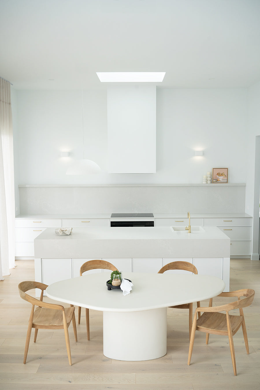 Saint Tropez Dining Table with ivory micro cement finish – modern coastal design with organic shape and refined matte texture.  Styled beautifully in this luxury coastal home 1