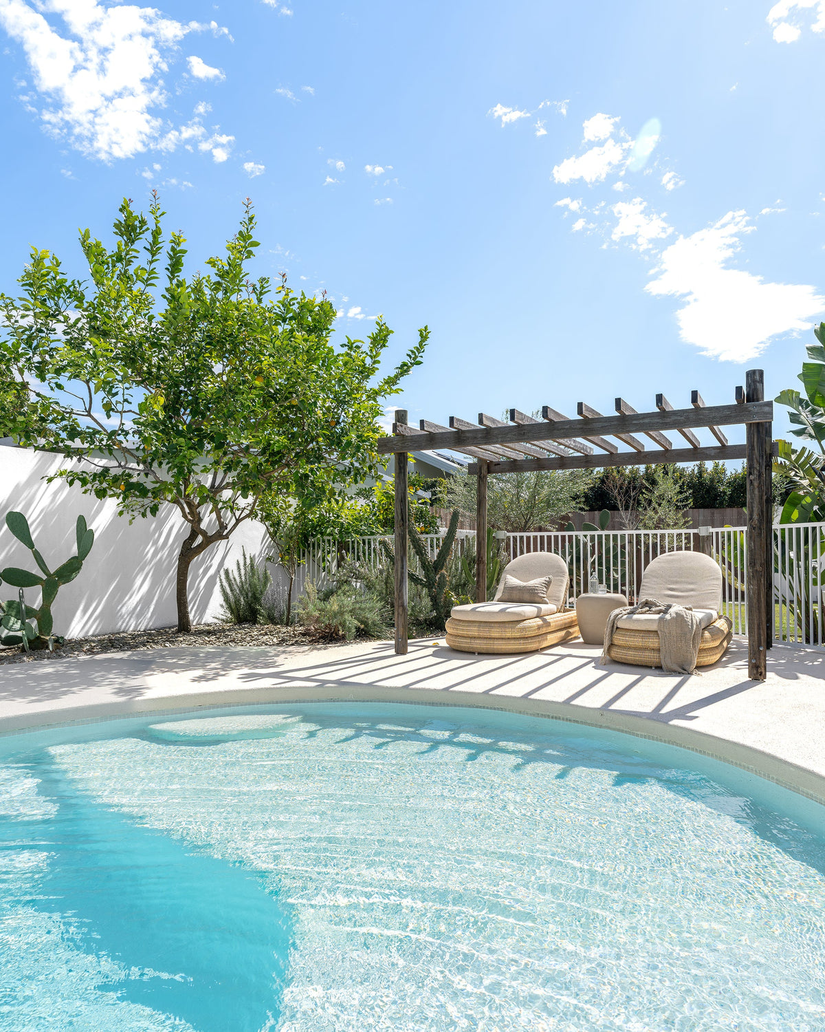 Satori outdoor sun loungers styled beside a swimming pool in an outdoor garden setting