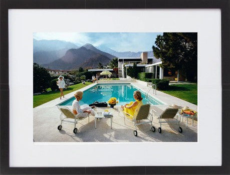 Slim Aarons Poolside Gossip photographic print, iconic Palm Springs 1970 image featuring Lita Baron, Nelda Linsk, and Helen Dzo Dzo, premium artwork with mat board and white self-border. Black Frame.