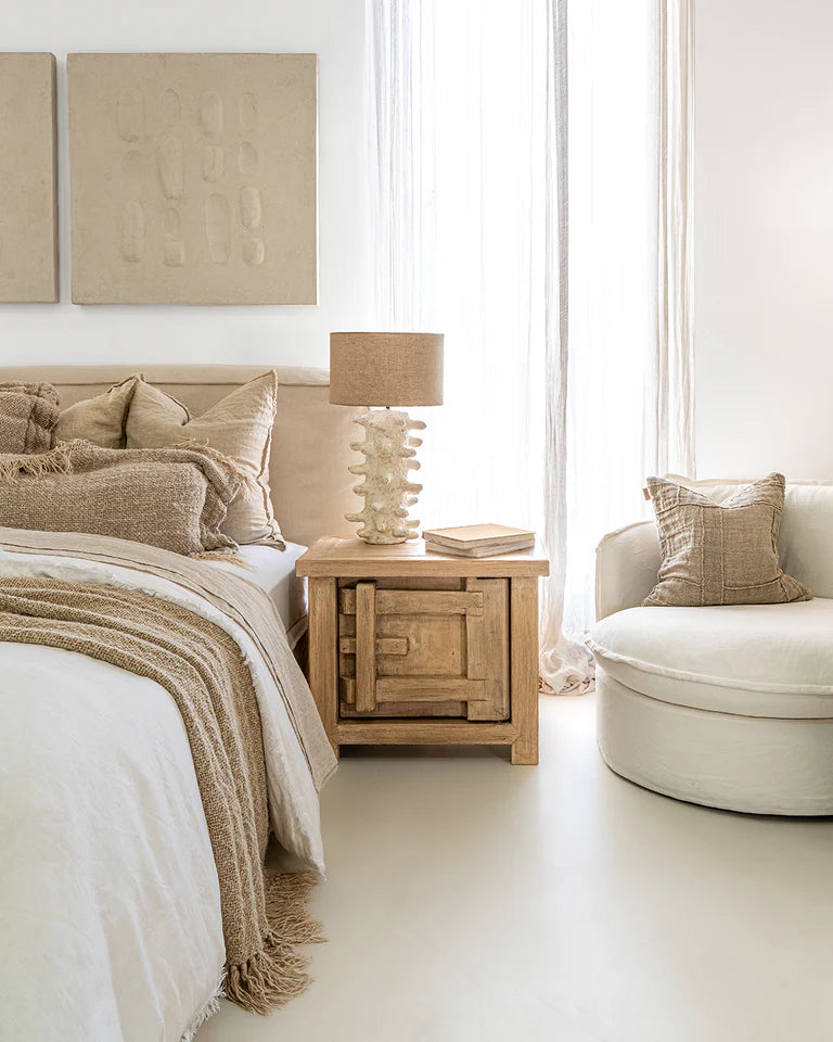 Bulu Bedside Table with right-hand door, handcrafted from reclaimed timber with natural weathered texture and carved details, coastal organic furniture with timeless character.  Modern coastal luxe bedroom interior.