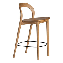 Load image into Gallery viewer, Loki Bar Chair in solid oak with natural finish, featuring sculptural minimalist design, rich wood grain, and black iron footrest for a modern touch. Side angle perspective.