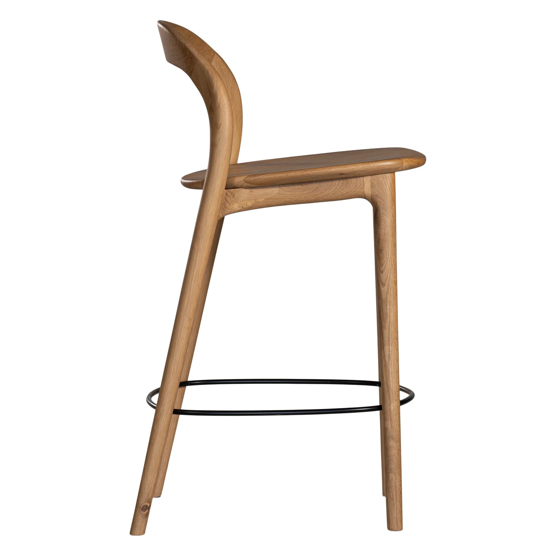Loki Bar Chair in solid oak with natural finish, featuring sculptural minimalist design, rich wood grain, and black iron footrest for a modern touch. Side perspective.