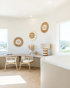 Rundu Table Lamp handcrafted from solid munggur wood with hand-carved textured grooves, showcasing natural wood variations and a soft ambient glow.  Styled beautifully in this coastal home.