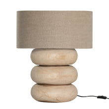 Load image into Gallery viewer, Rundu Table Lamp handcrafted from solid munggur wood with hand-carved textured grooves, showcasing natural wood variations and a soft ambient glow.