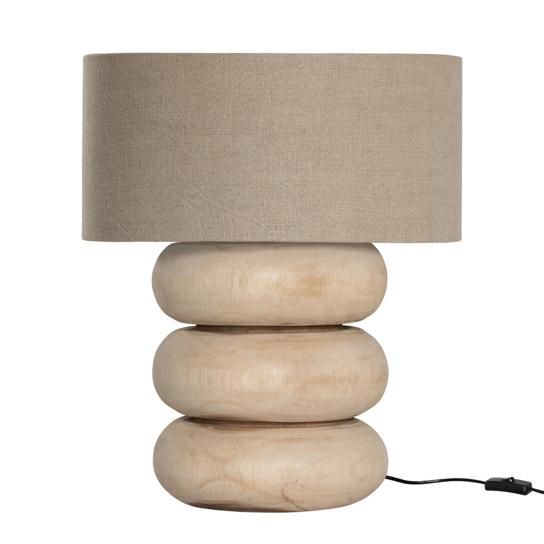 Rundu Table Lamp handcrafted from solid munggur wood with hand-carved textured grooves, showcasing natural wood variations and a soft ambient glow.