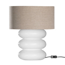 Load image into Gallery viewer, Rundu Table Lamp handcrafted from solid munggur wood with hand-carved textured grooves, showcasing natural wood variations and a soft ambient glow. White base with oatmeal shade.