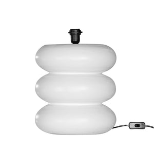Rundu Table Lamp handcrafted from solid munggur wood with hand-carved textured grooves, showcasing natural wood variations and a soft ambient glow. Close up white base.