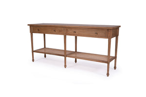 Whitsunday Wide Console Table in natural mahogany with two drawers and rattan shelf, coastal style furniture with storage. Front angle perspective.