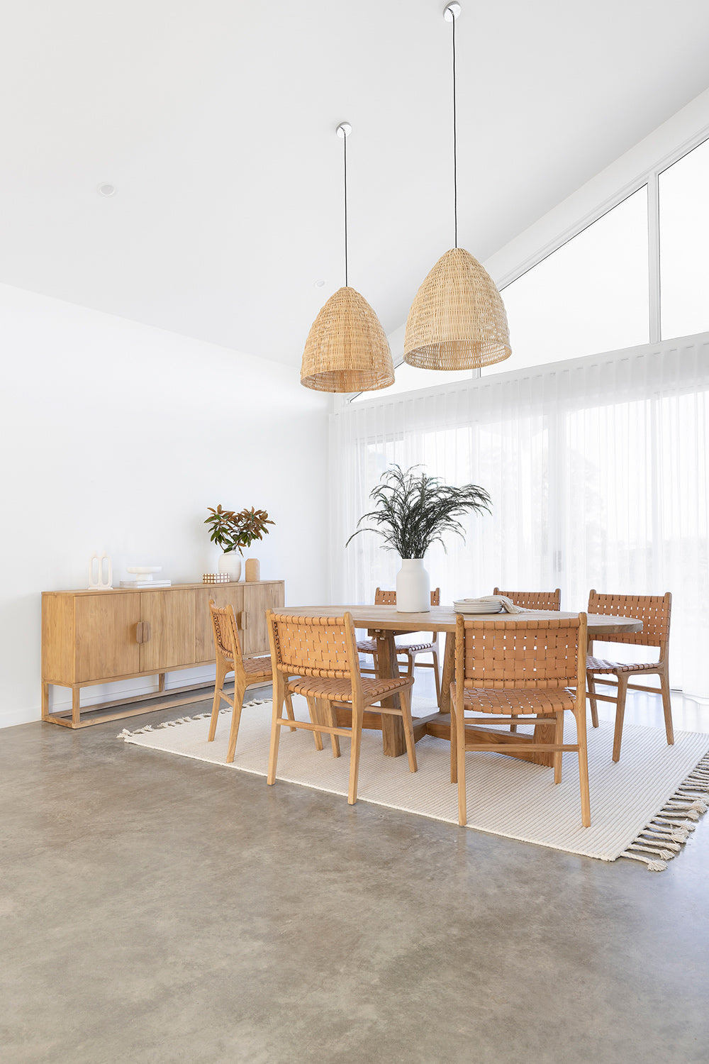 Dining chair with natural woven leather straps and sleek modern design, crafted for style and comfort. Styled perfectly in this modern coastal home.  Magnolia Lane
