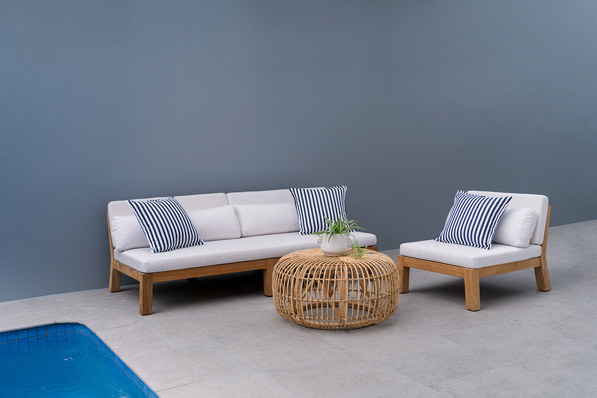 Bedarra teak outdoor three-seater sofa, poolside setting with the sofa, matching armless chair and woven coffee table