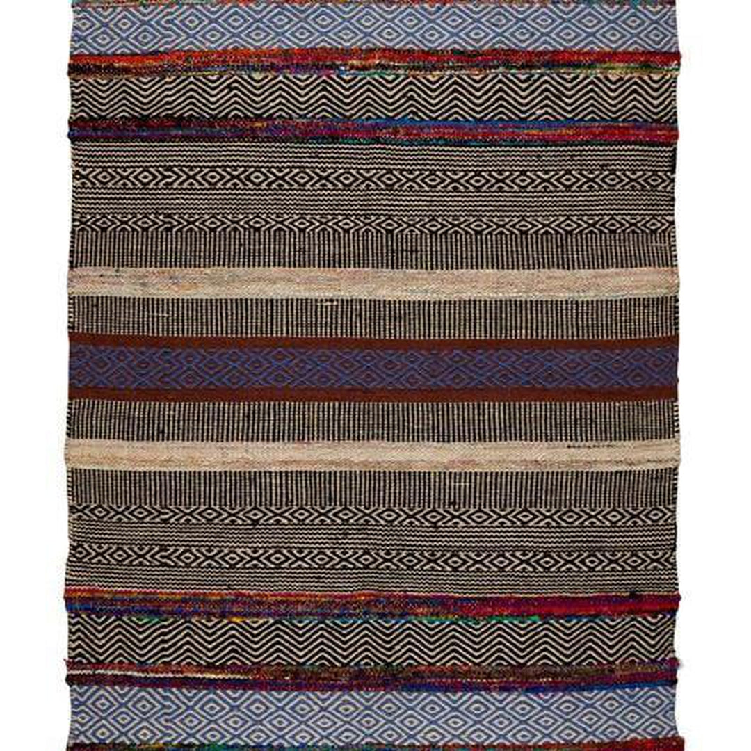 Bold patterned rug with natural, black, and blue tones plus pops of color, inspired by global cultures, adding style and character to any room. Magnolia Lane