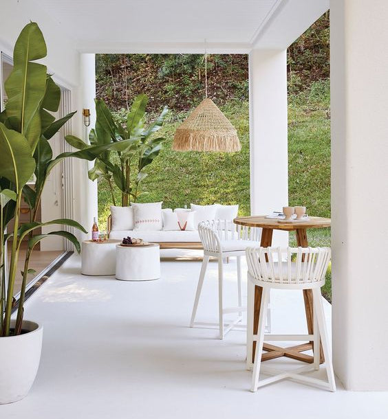 White Trunk Coffee Table styled beside woven lounge seating and greenery